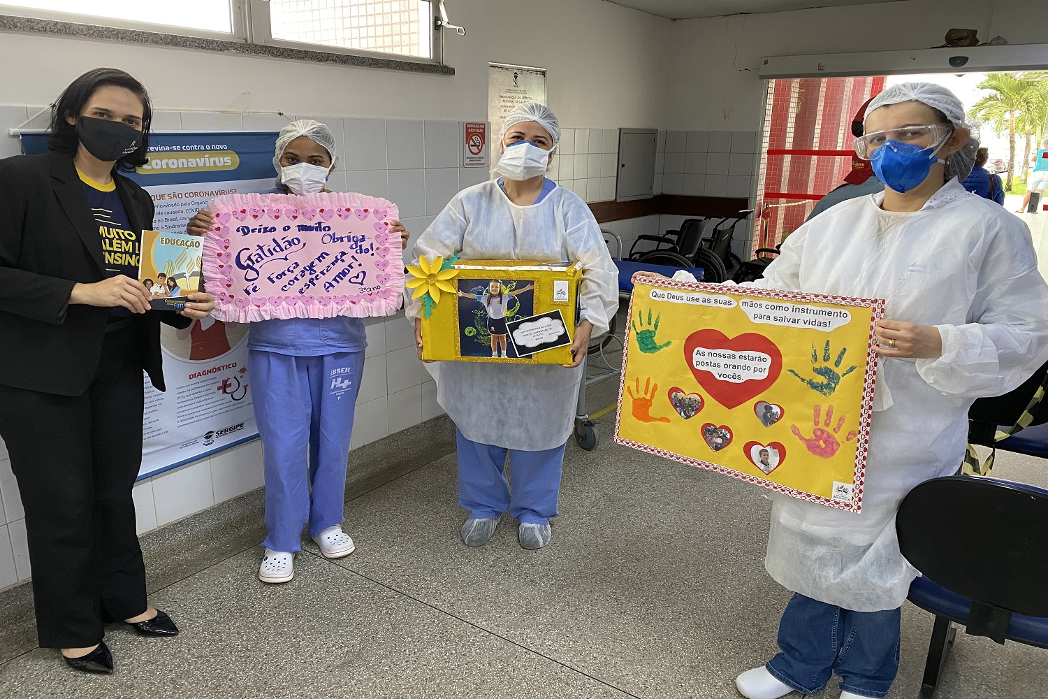 Representantes de escola entregam aos profissionais da saúde, cartas e cartazes feitos por crianças