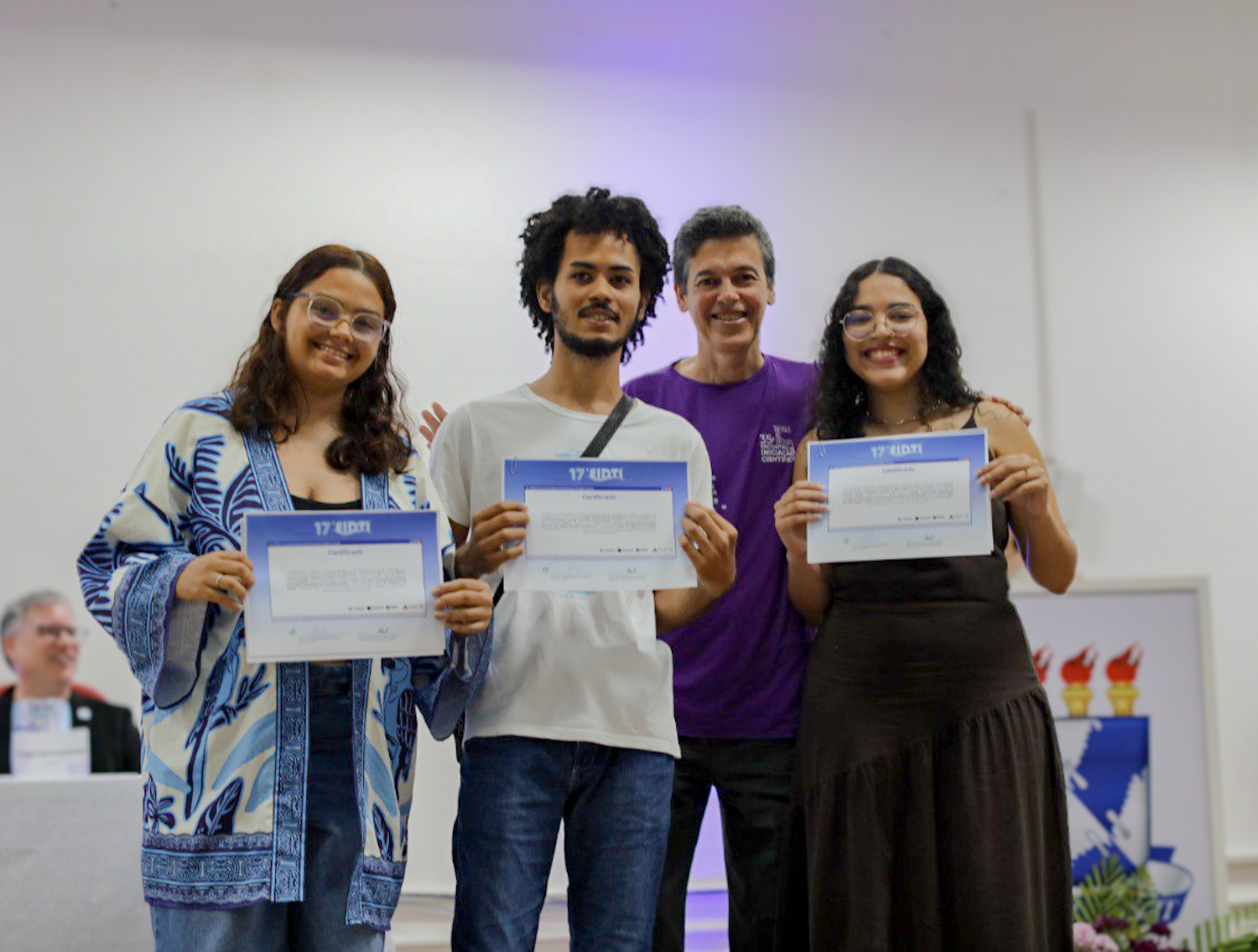 Almir Vinícius e outras duas alunas premiadas receberem prêmio das mãos do reitor  (Foto: Elisa Lemos/Ascom UFS)