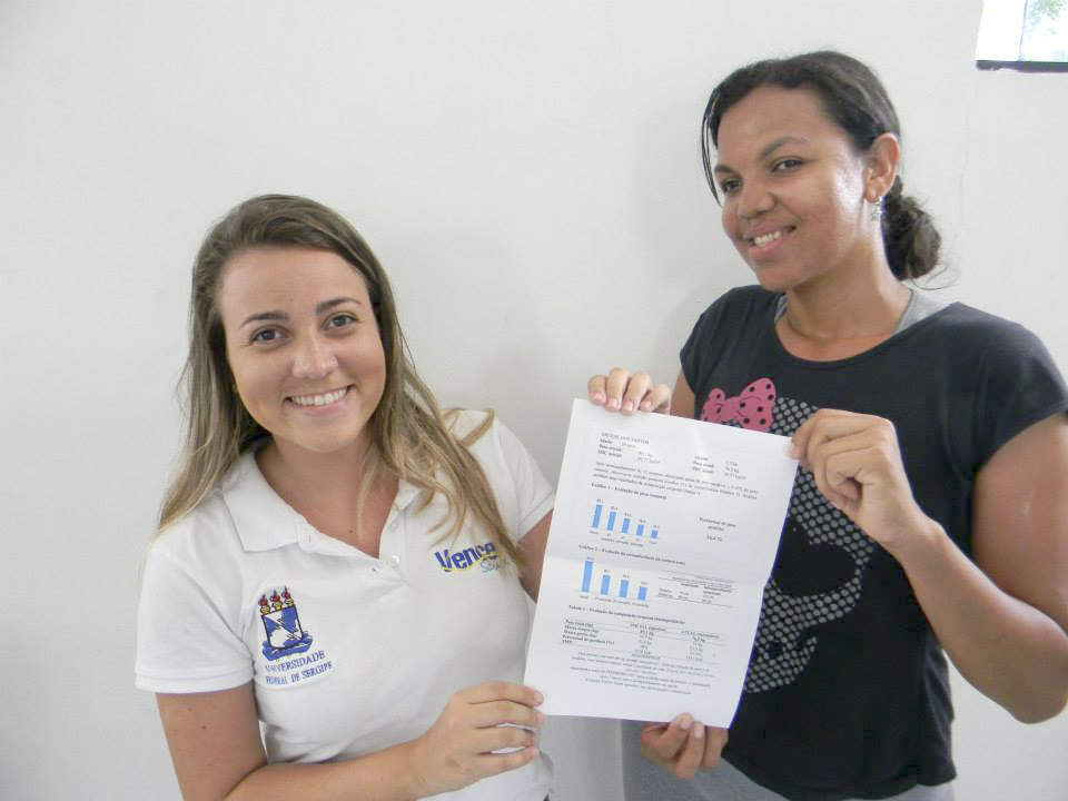 Nutricionista Bárbara Chagas (e) concede certificado a participante do projeto.